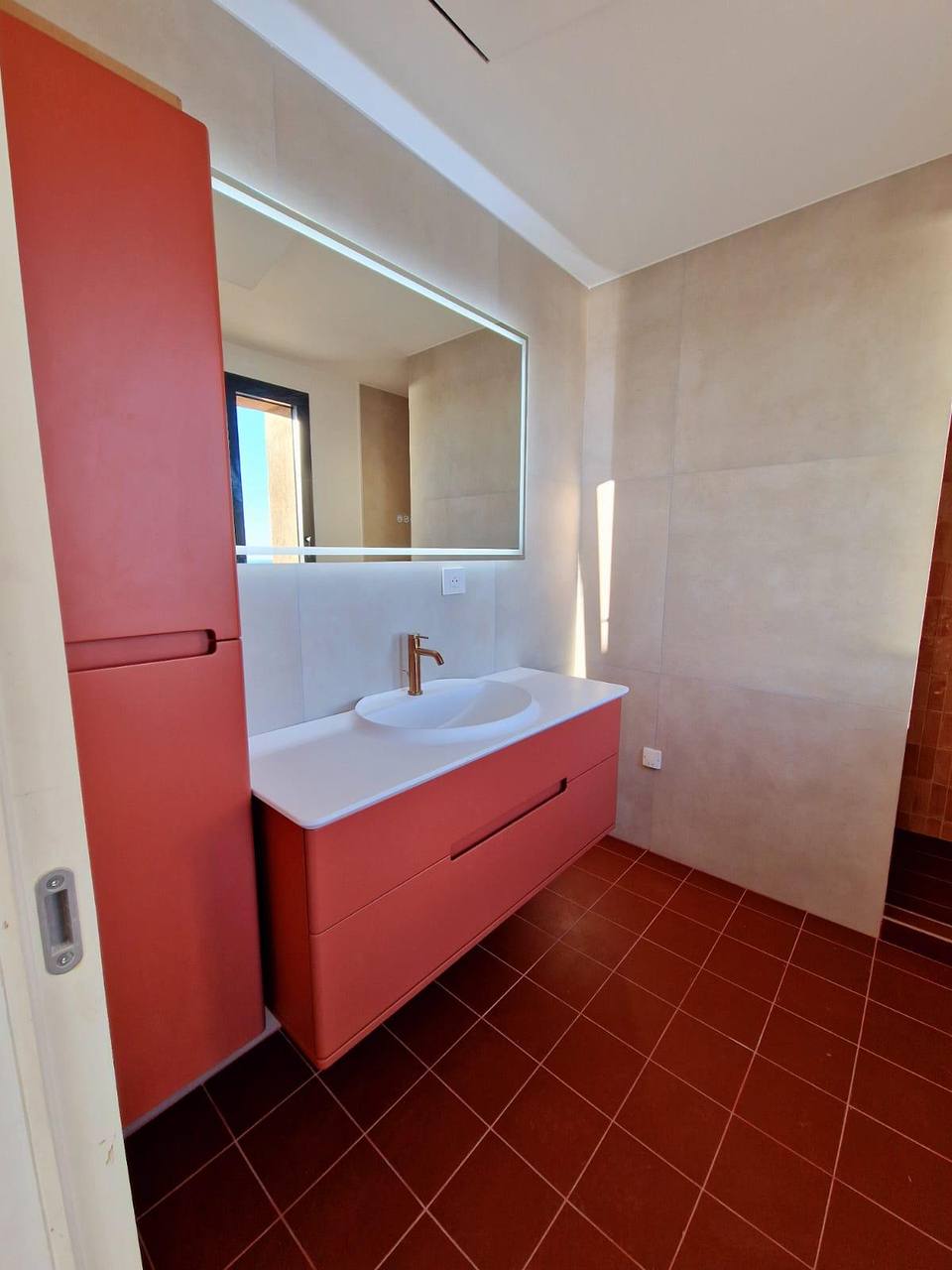 Meuble vasque terracotta et miroir lumineux, villa dans la baie d'Agay